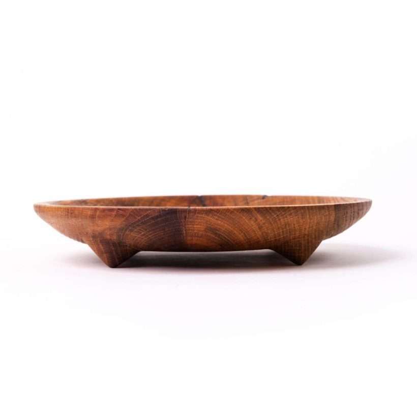 Drveni tanjir za posluženje napravljen iz celog komada drveta. Izradjen od hrasta, rustičan i sa nogicama. Slikano sa strane.